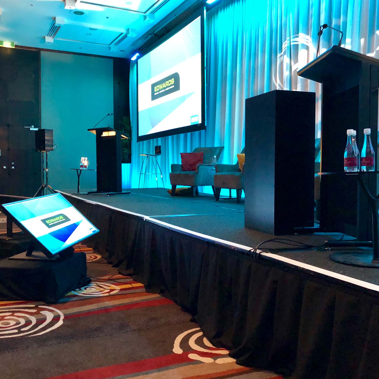A lectern on a stage with presenters comfort monitor in front